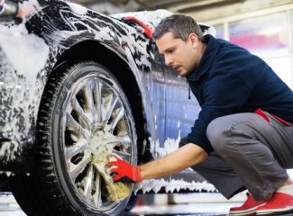 man scrubbing wheels clean